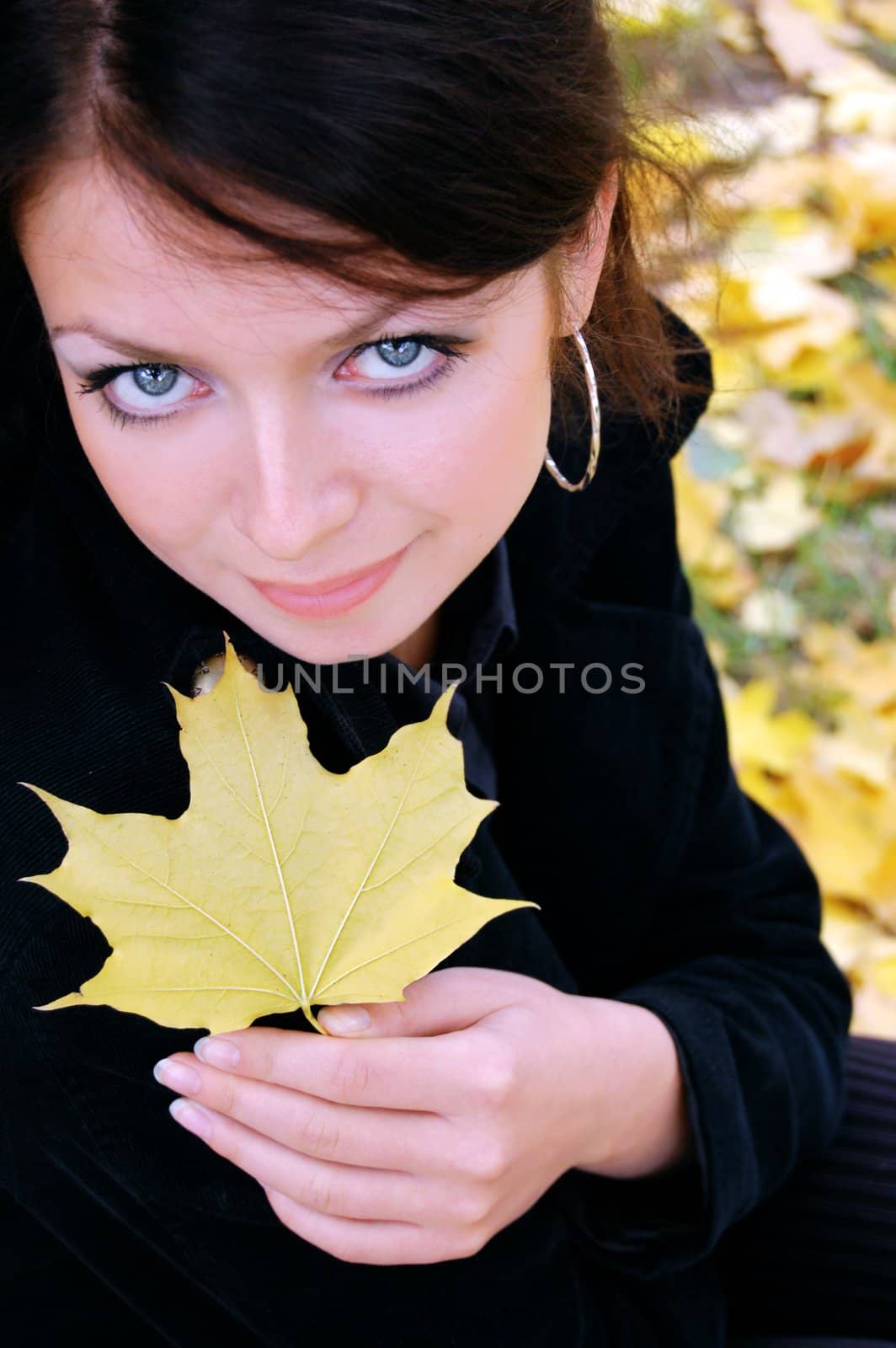 autumn girl portrait outdoors with yellow leaf