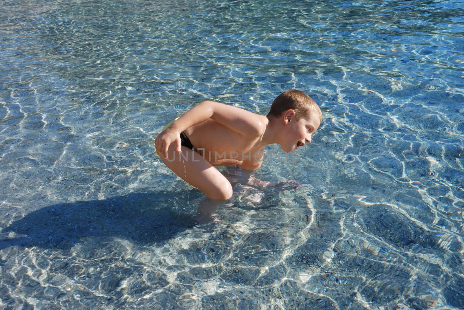 a boy is smiling and playing in a water