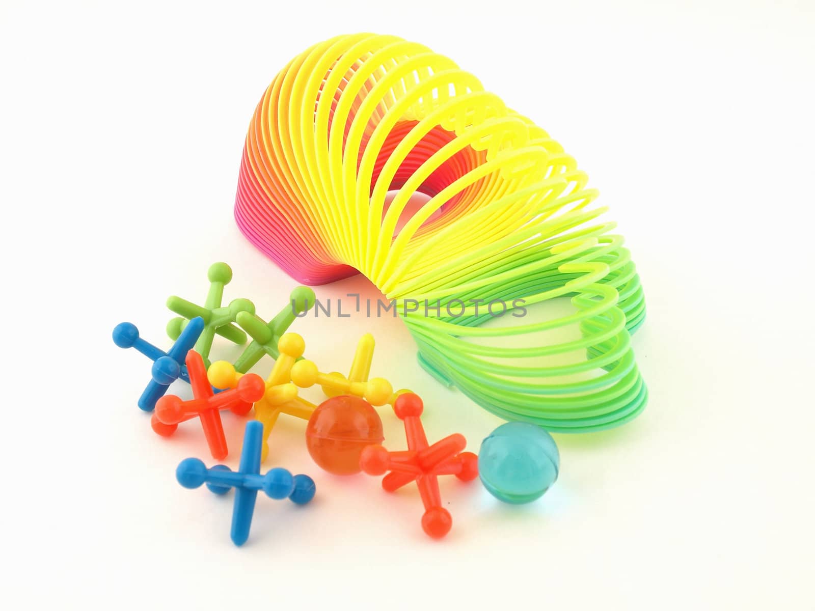 A colorful heart slinky and jacks isolated on a white background