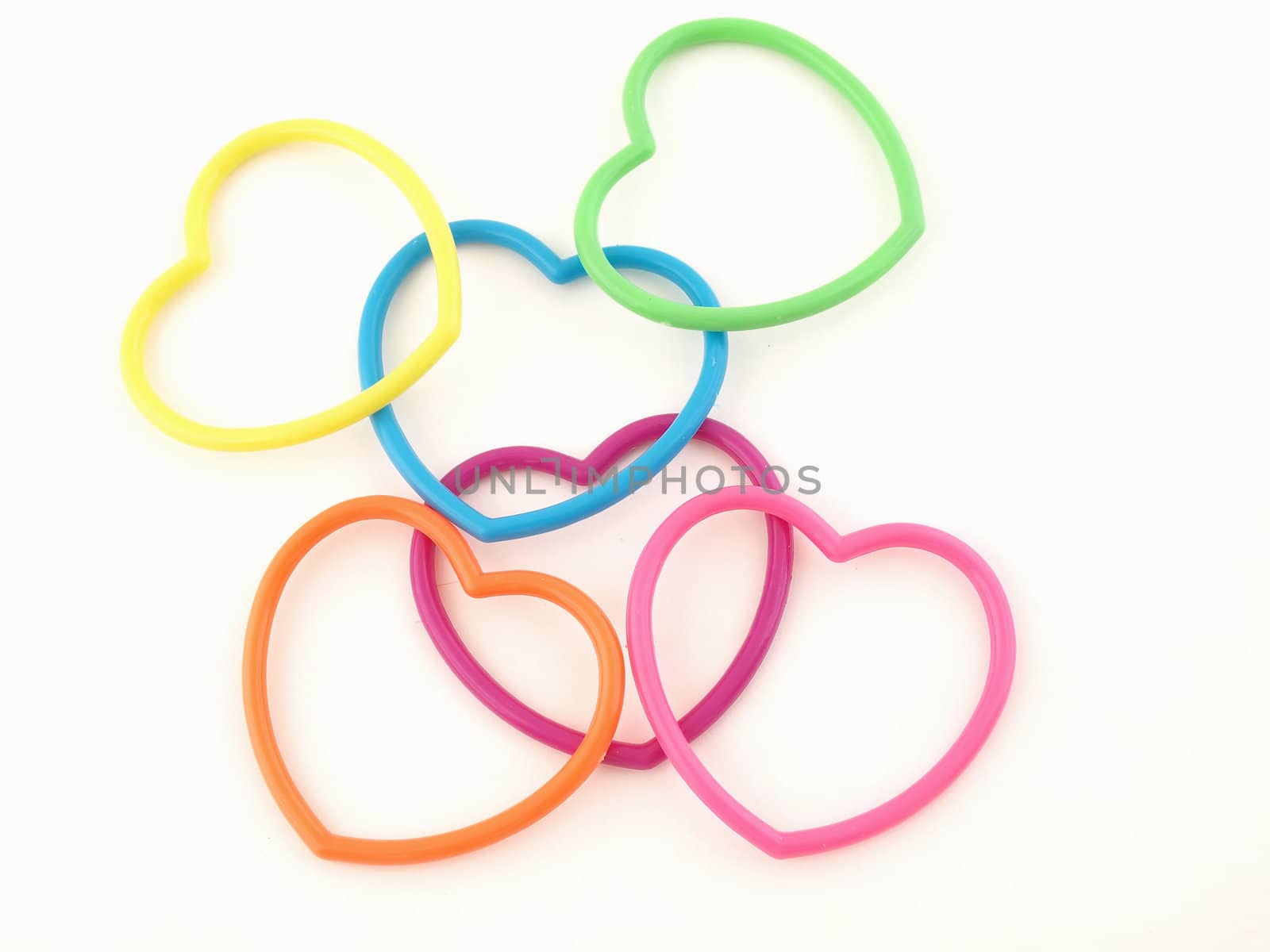 Six very colorful plastic hearts isolated on a white background