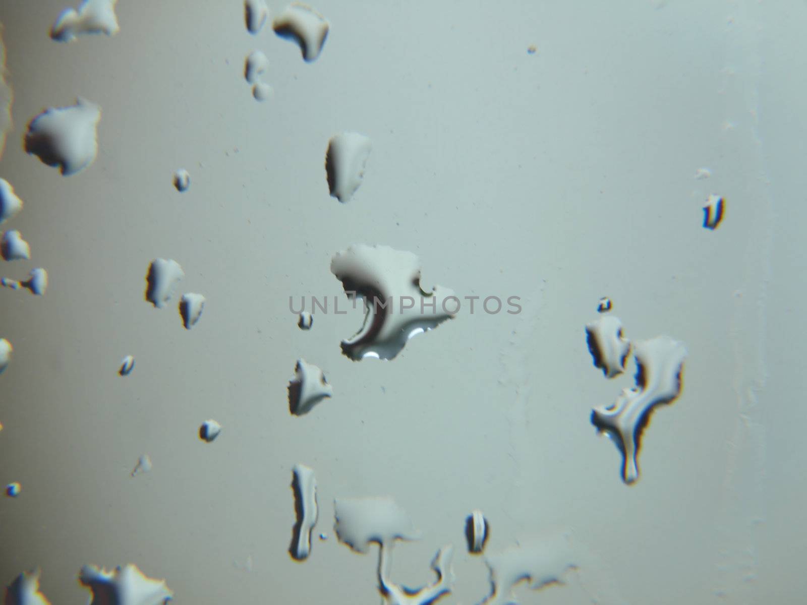 Abstract background design of raindrops forming on a window pane.