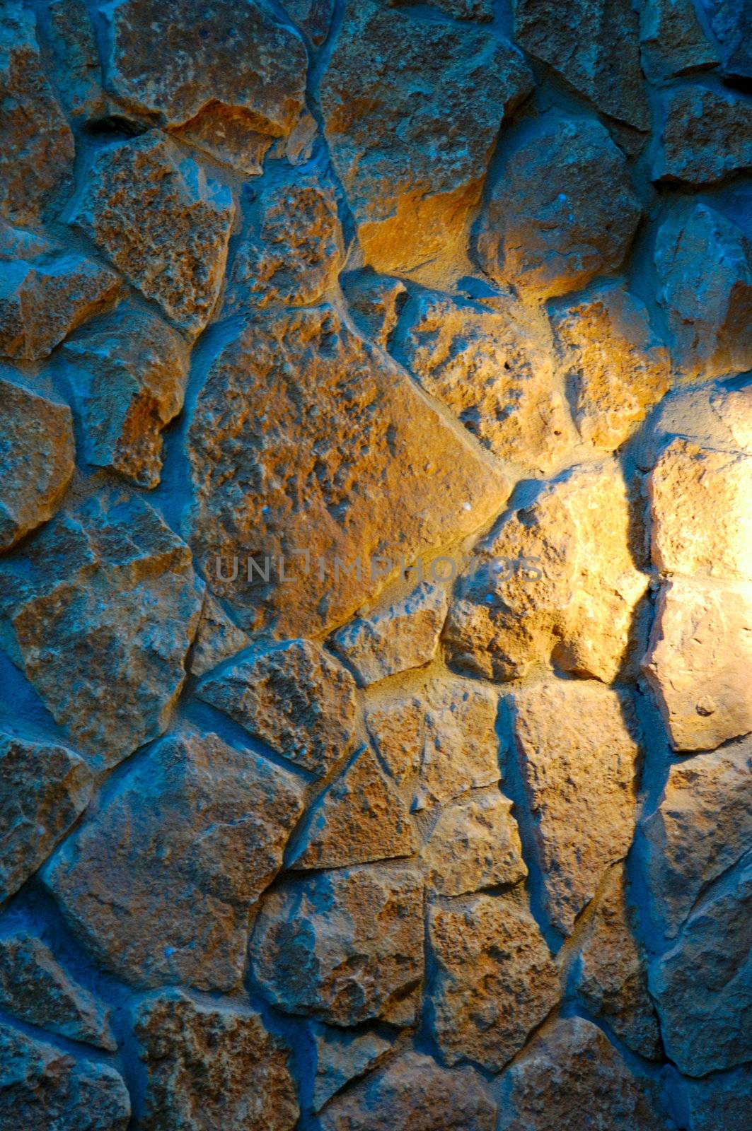 old-style wall of wild stones with decorative lighting