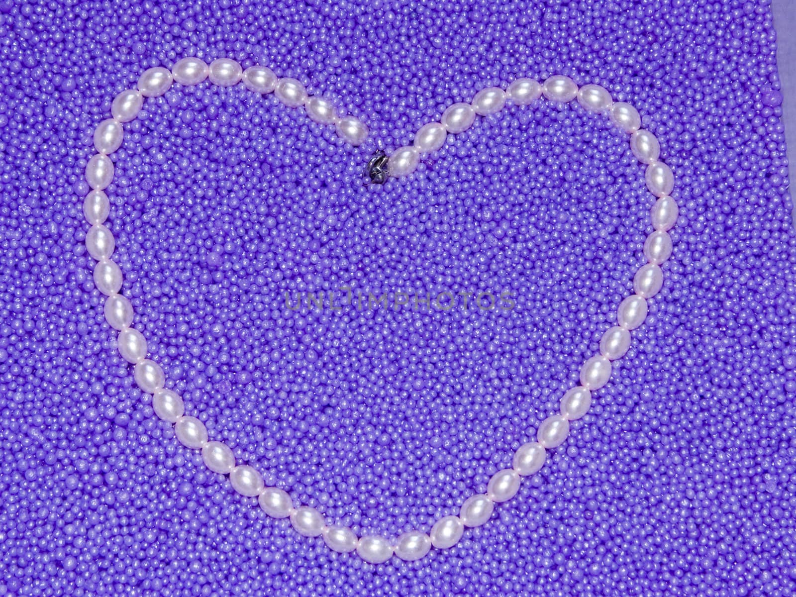 heart from pearls beads on a lilac background by soloir