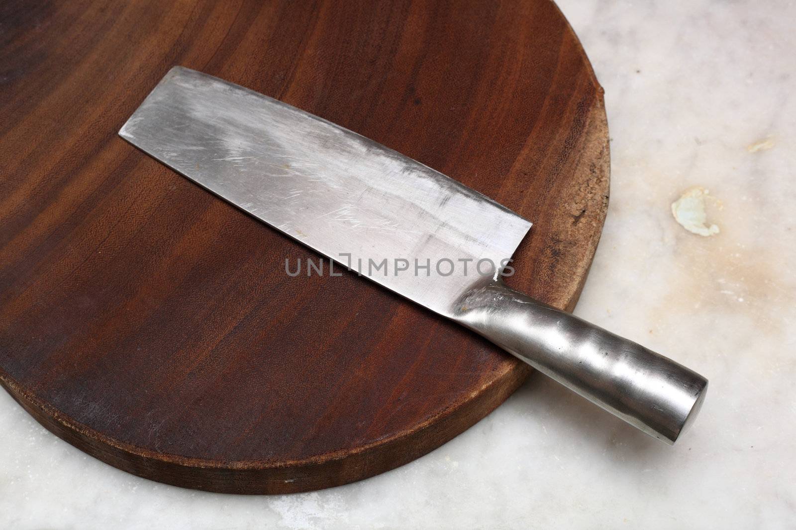 Closeup image of chinese kitchen knife on cutting board.