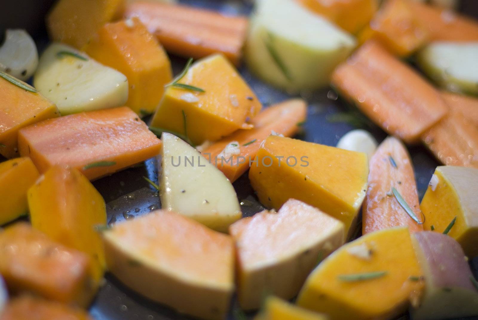 a tray of seasoned winter vegetables ready for roasting