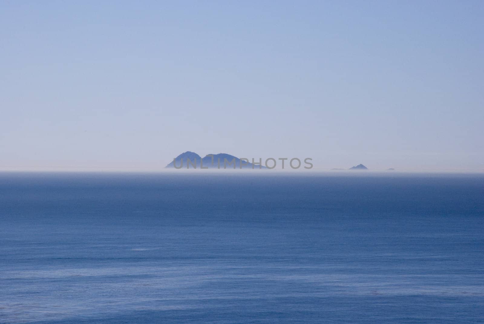 Island rises above a foggy horizon