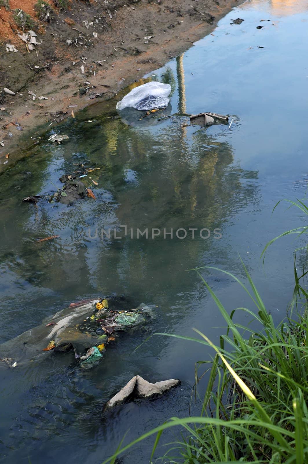 Dirty river pollution with plastic bag and toxic waste. Please care for the environment