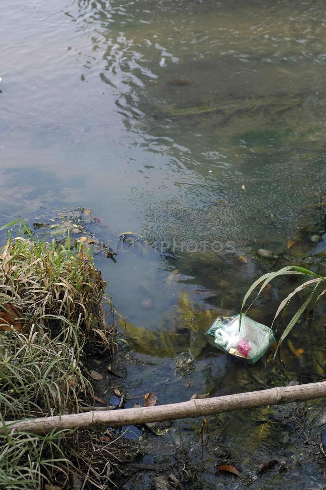 Dirty river pollution with plastic bag and toxic waste. Please care for the environment