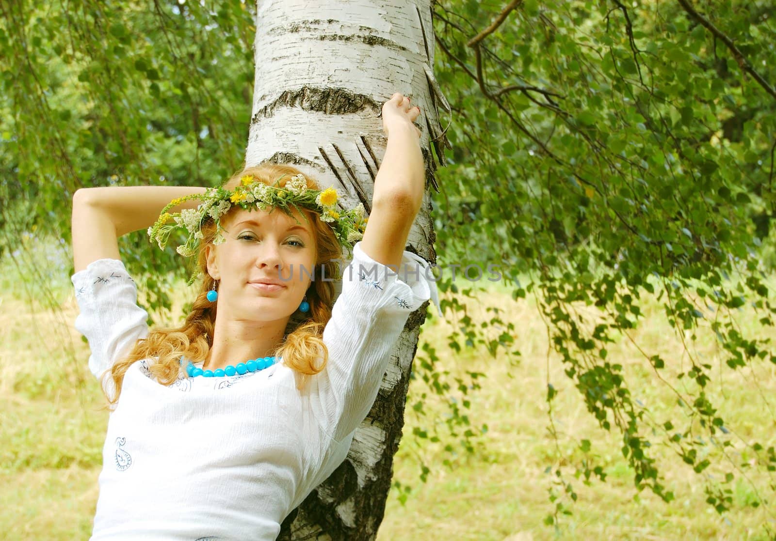 beautiful redhead girl with flower diadem near birch