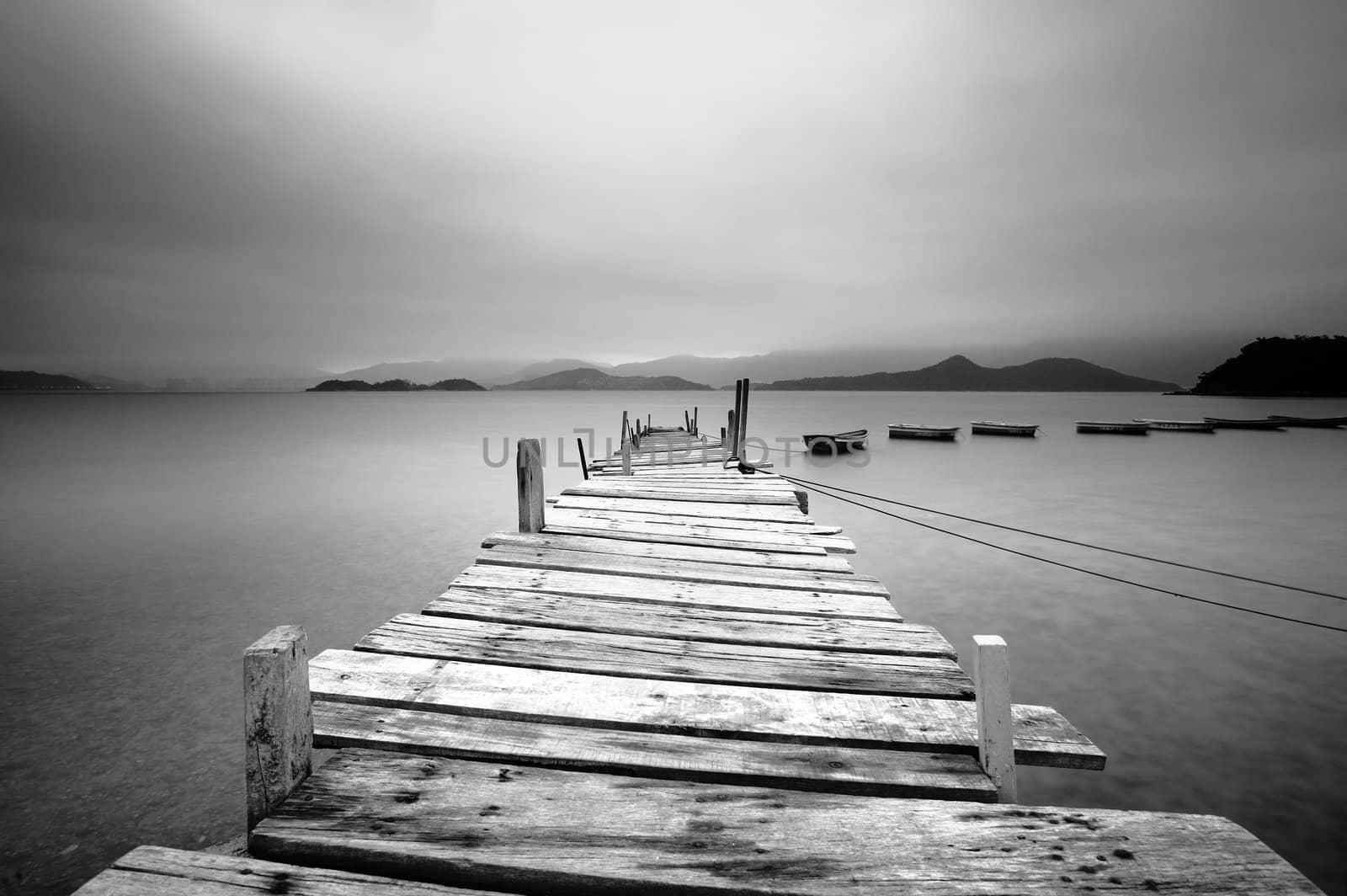 Looking over a pier and boats, black and white by leungchopan