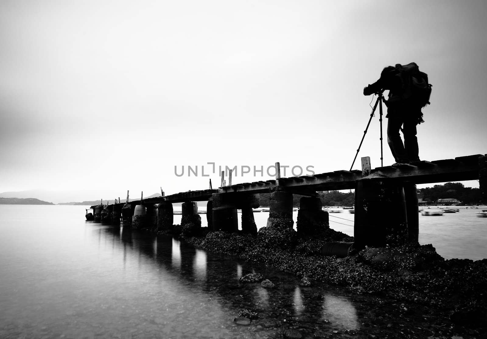 a wooden pier with a man , black and white