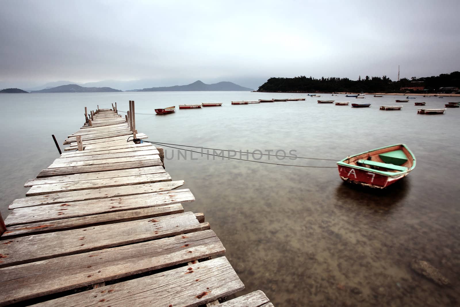 a wooden pier and boats by leungchopan