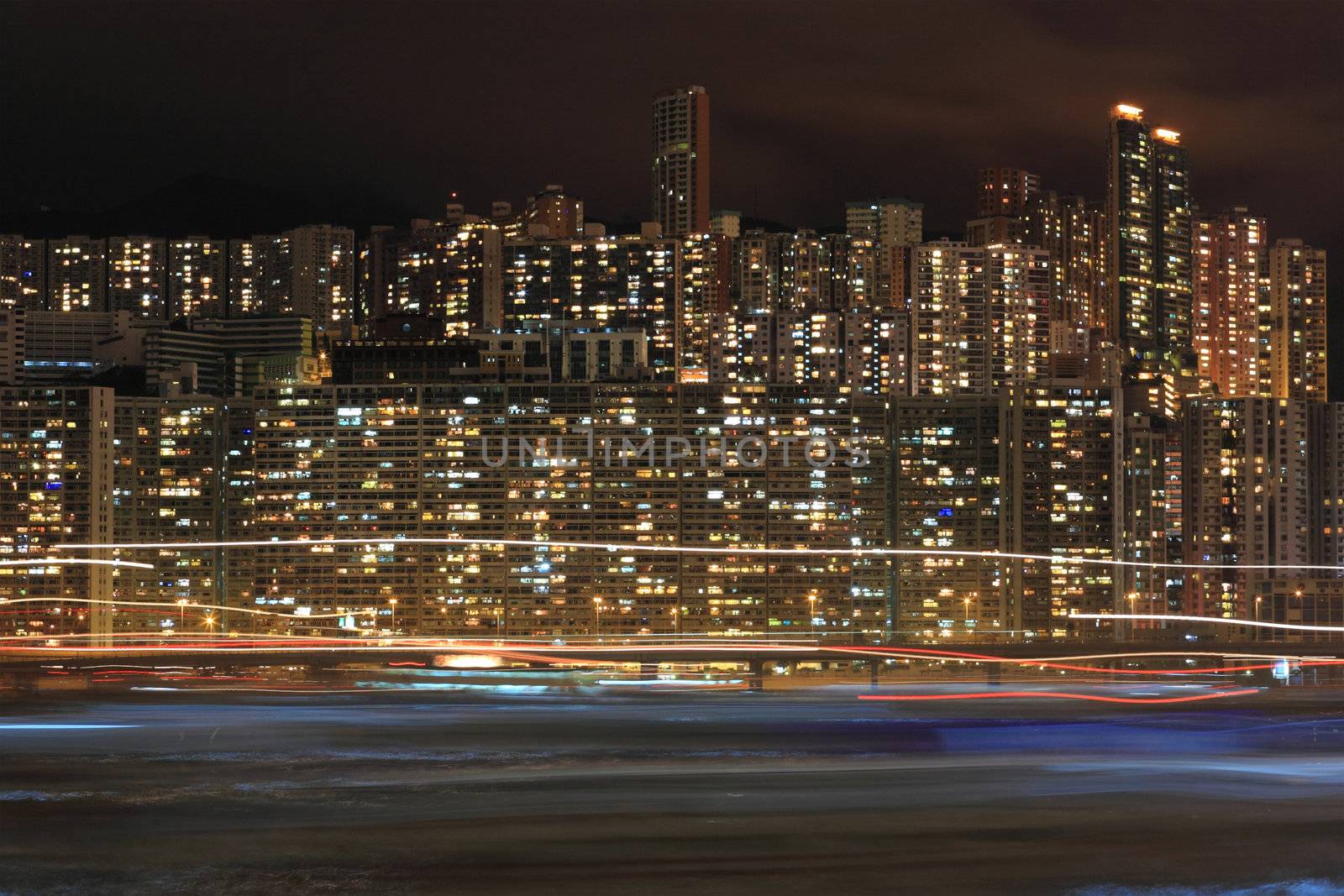 Hong Kong apartment block at night with ship light blur