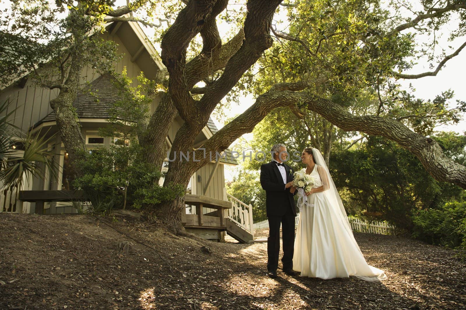 Mid-adult bride and groom standing outside of church.