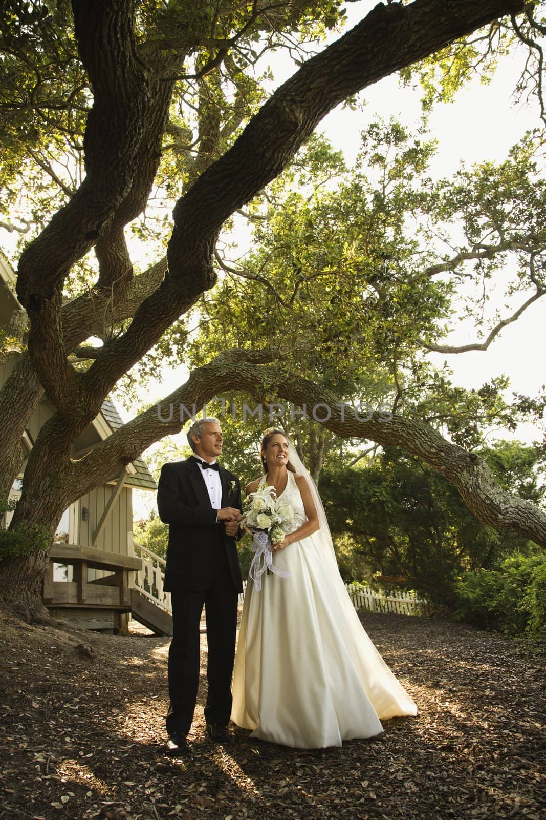 Mid-adult bride and groom standing outside of church.