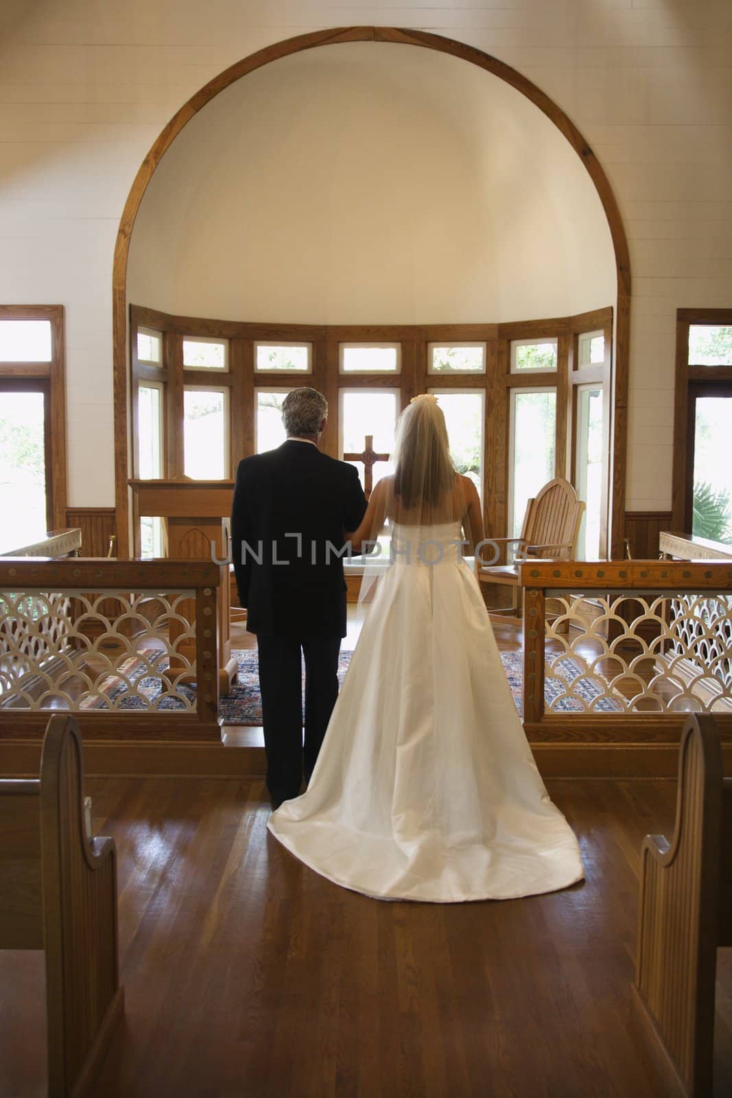 Portrait of bride and groom at alter of a church.