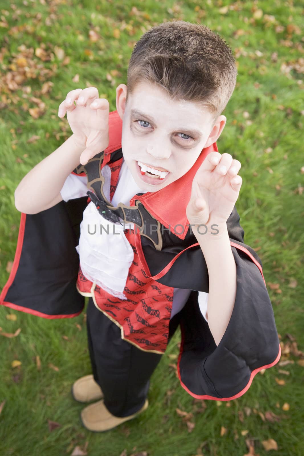 Young boy outdoors wearing vampire costume on Halloween by MonkeyBusiness