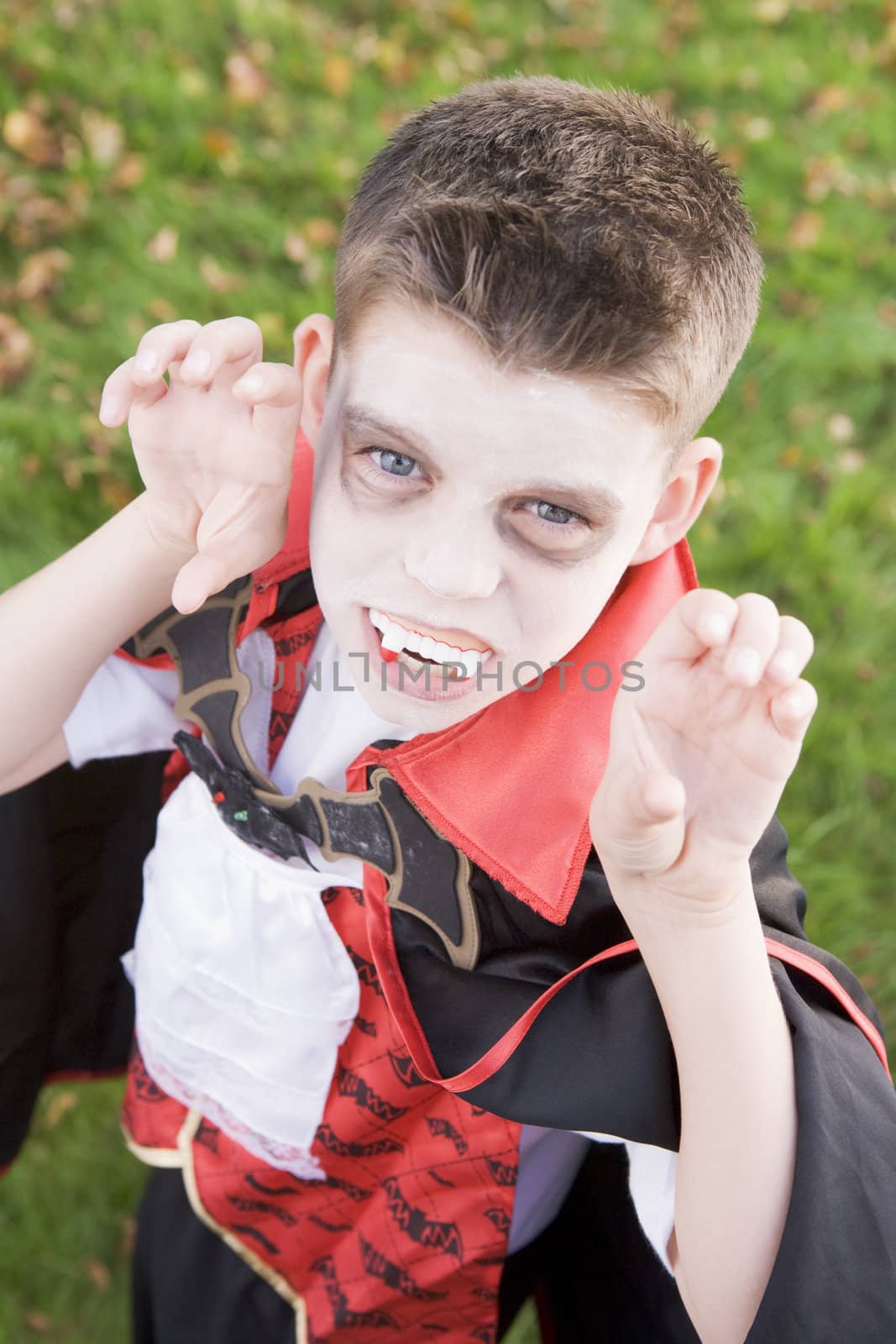 Young boy outdoors wearing vampire costume on Halloween by MonkeyBusiness