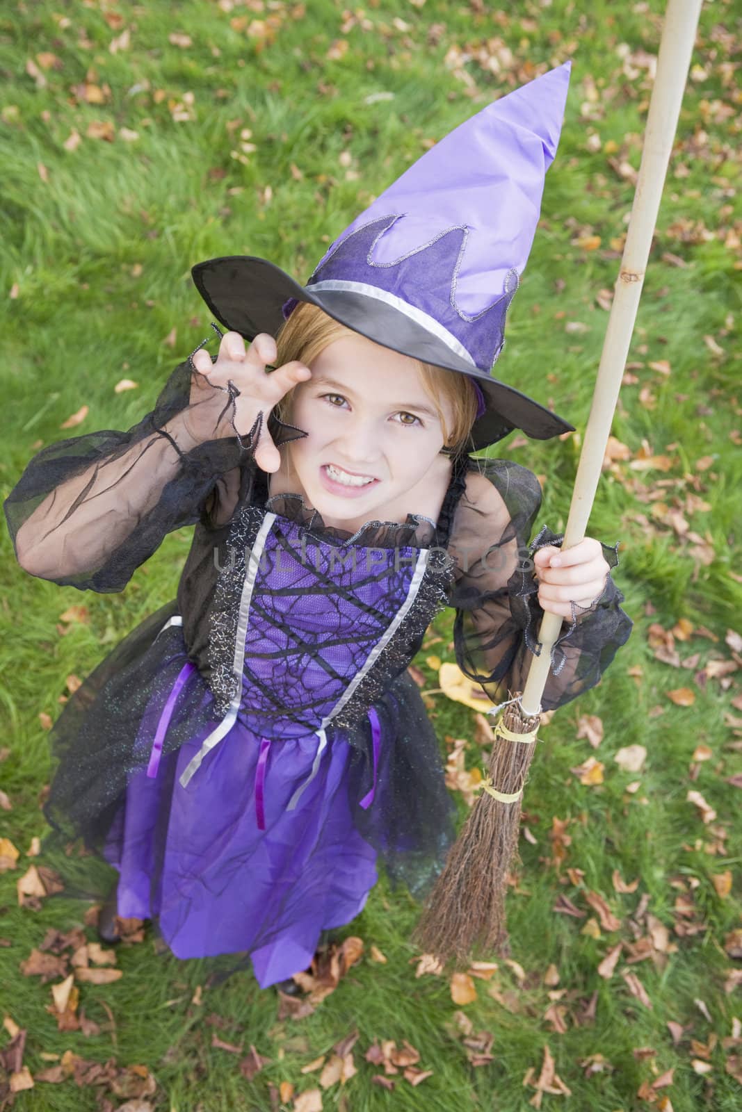 Young girl outdoors in witch costume on Halloween by MonkeyBusiness