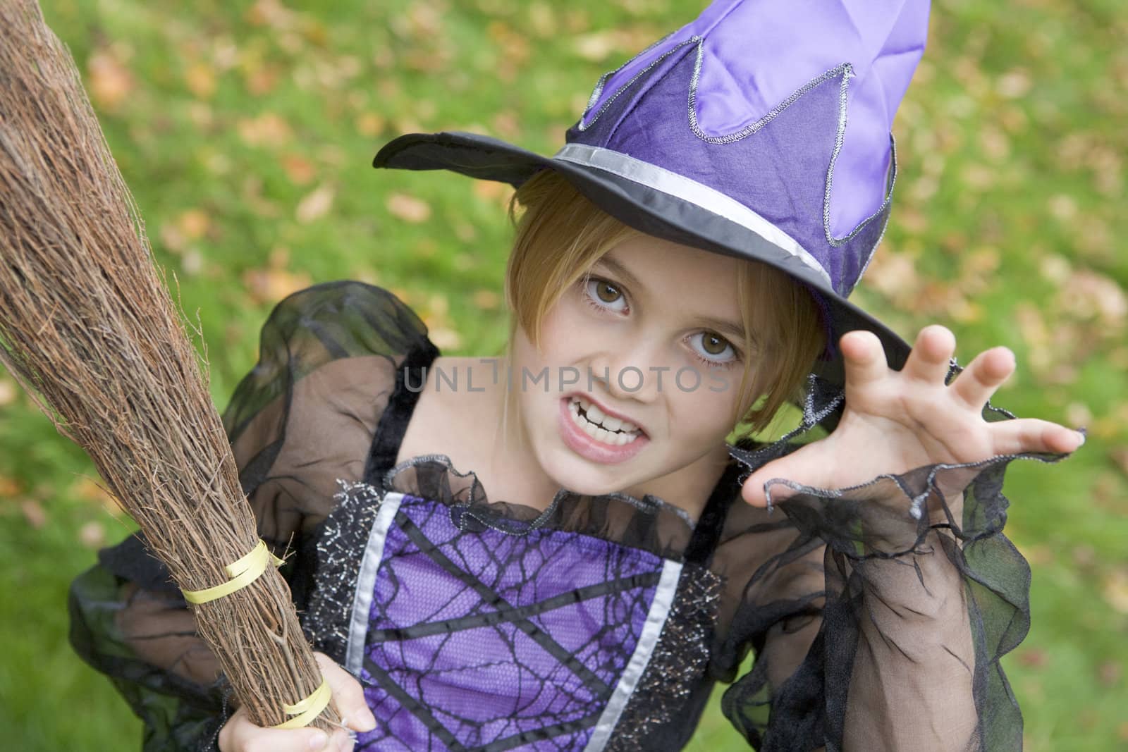Young girl outdoors in witch costume on Halloween by MonkeyBusiness