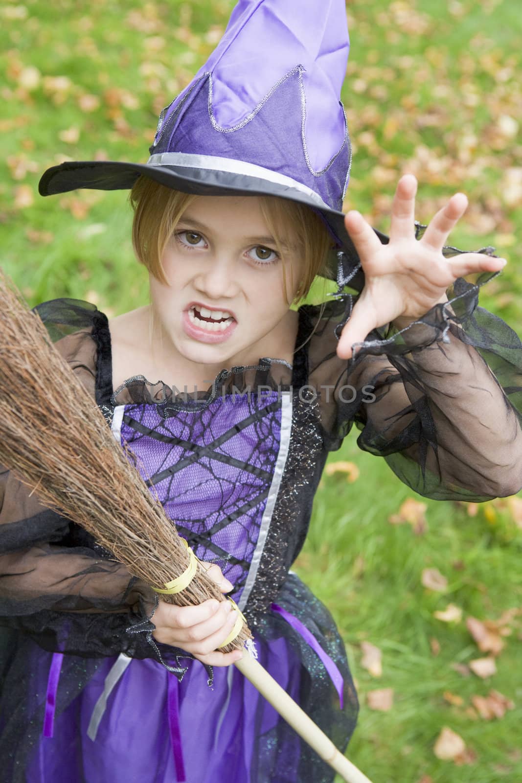 Young girl outdoors in witch costume on Halloween by MonkeyBusiness