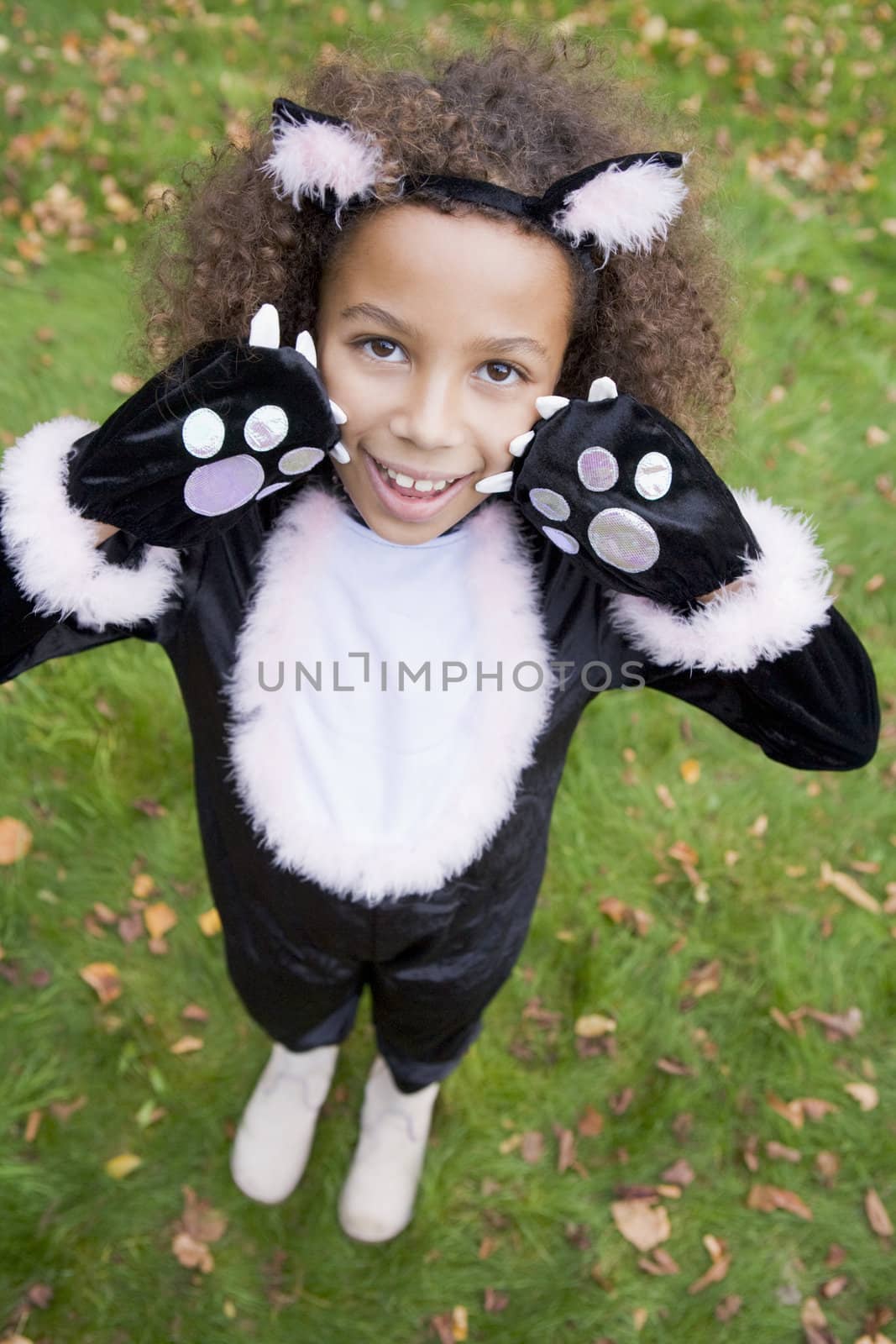 Young girl outdoors in cat costume on Halloween by MonkeyBusiness