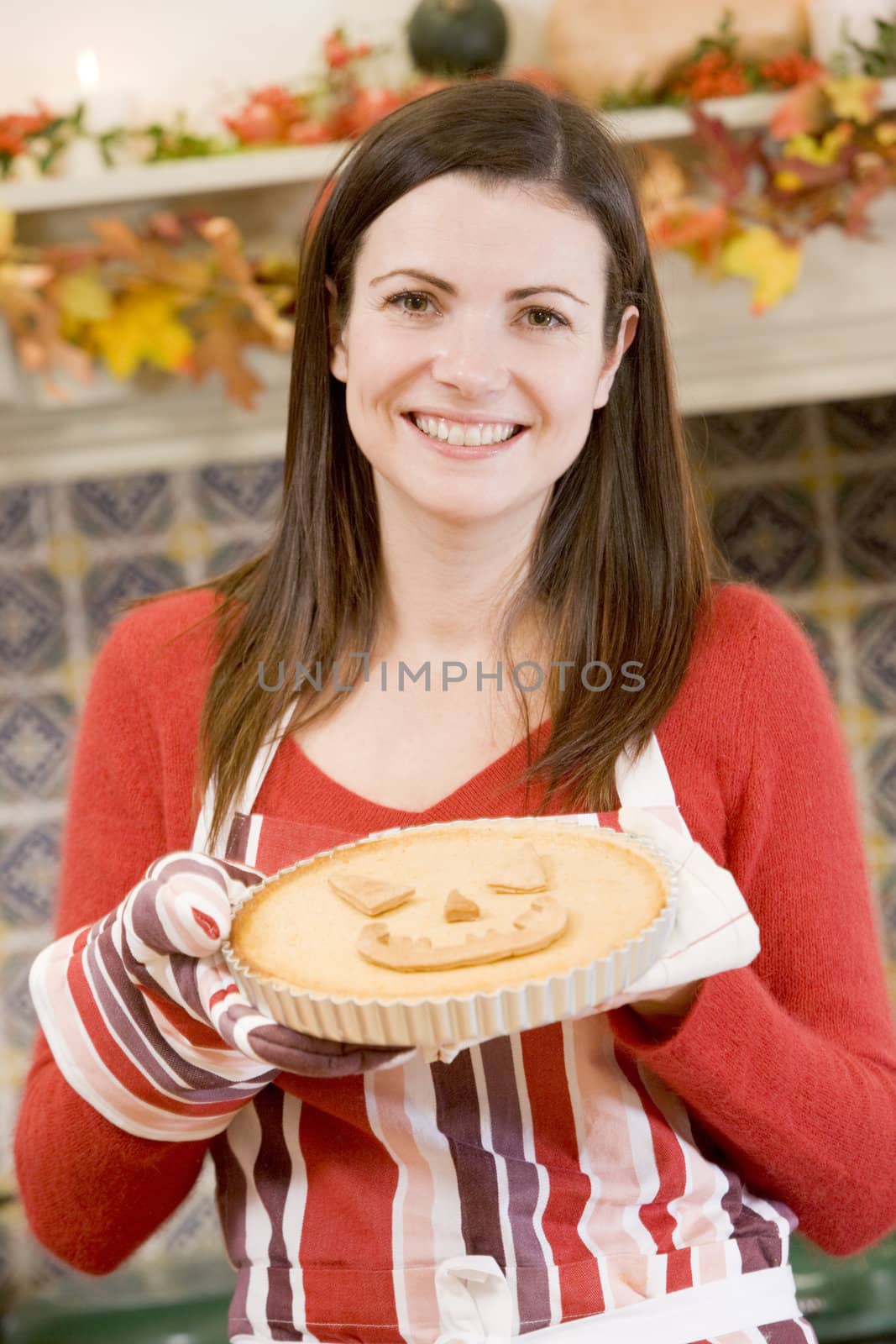 Woman in kitchen making Halloween treats and smiling by MonkeyBusiness