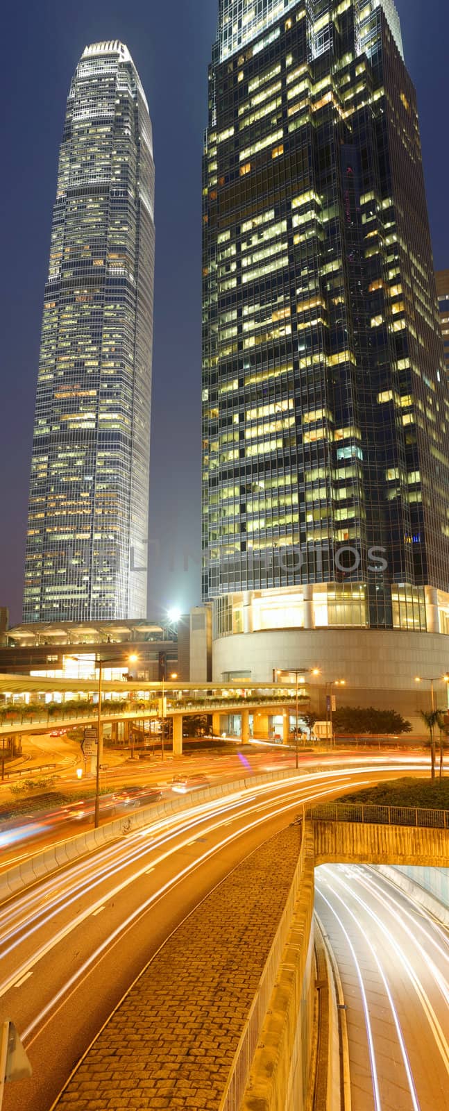 Night view of IFC (International Financial Centre) in Hong Kong with curving traffic light track.