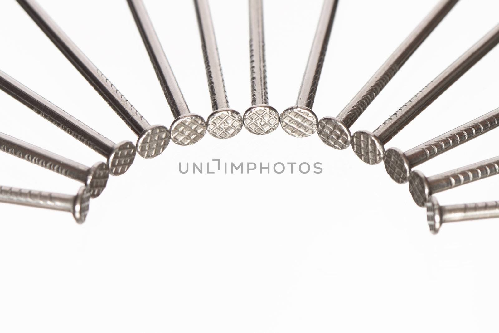 Few nails lying in a row on white background with copy space