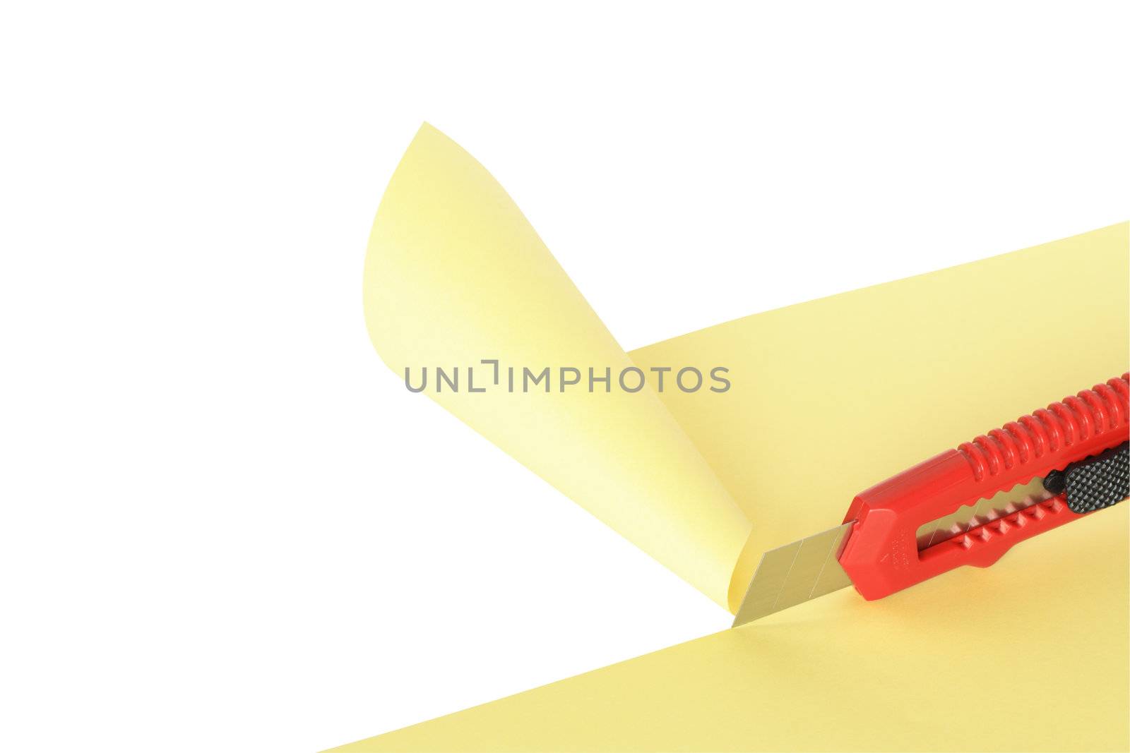 Red knife cutting yellow paper sheet. Isolated on white with clipping path