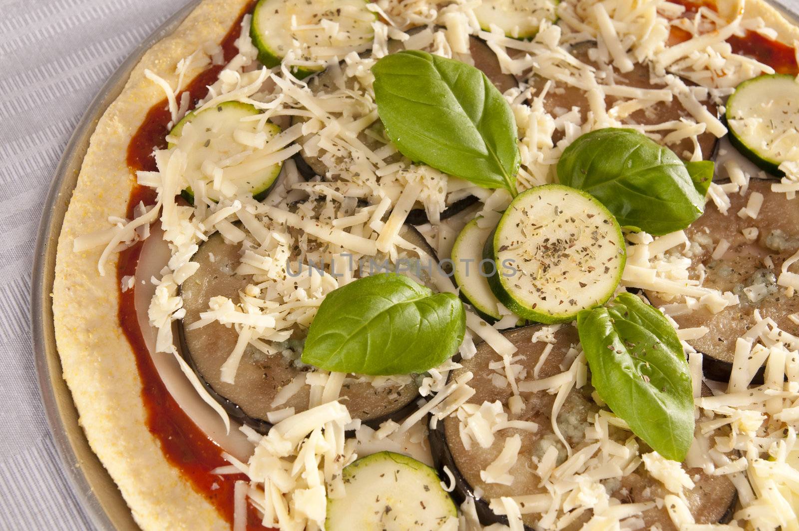 Uncooked pizza with eggplant and zucchini topping