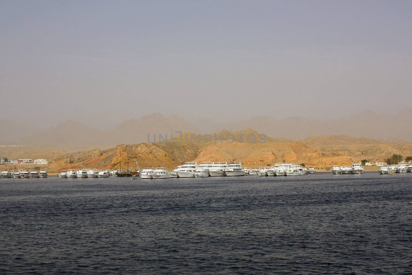 A beautiful landscape of Egypt - the ships at the port on the background of mountains.