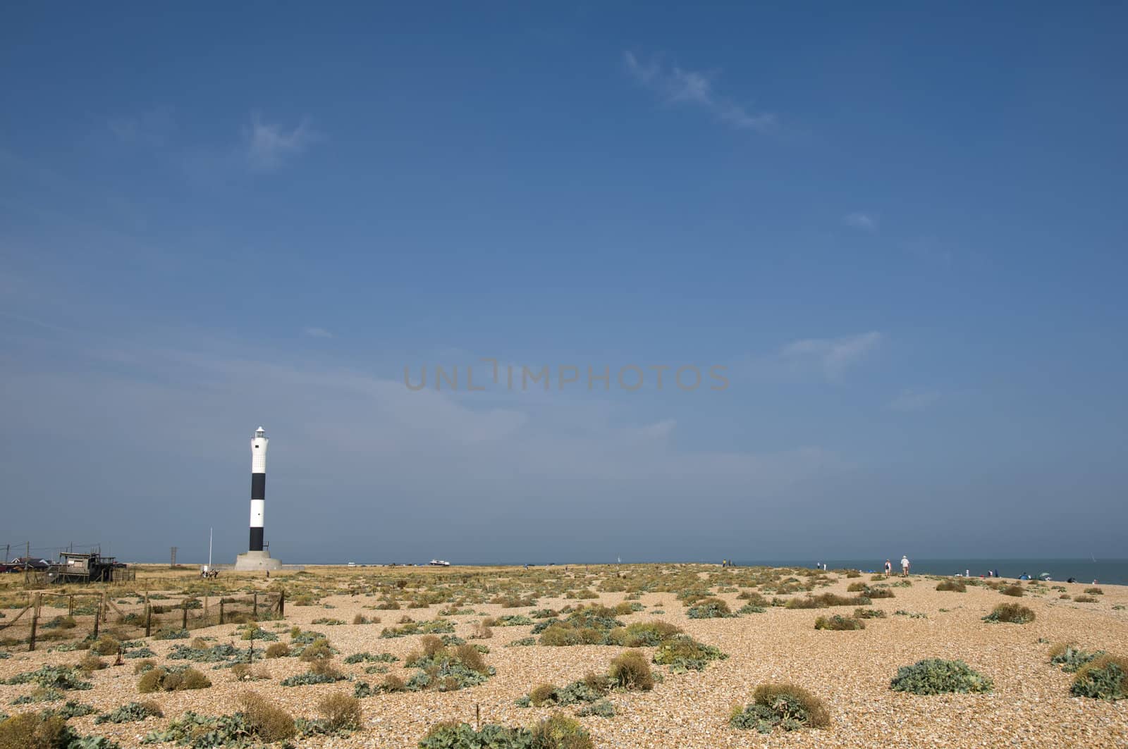 The pebble beach at Dungeness with the new lighthouse in the distance