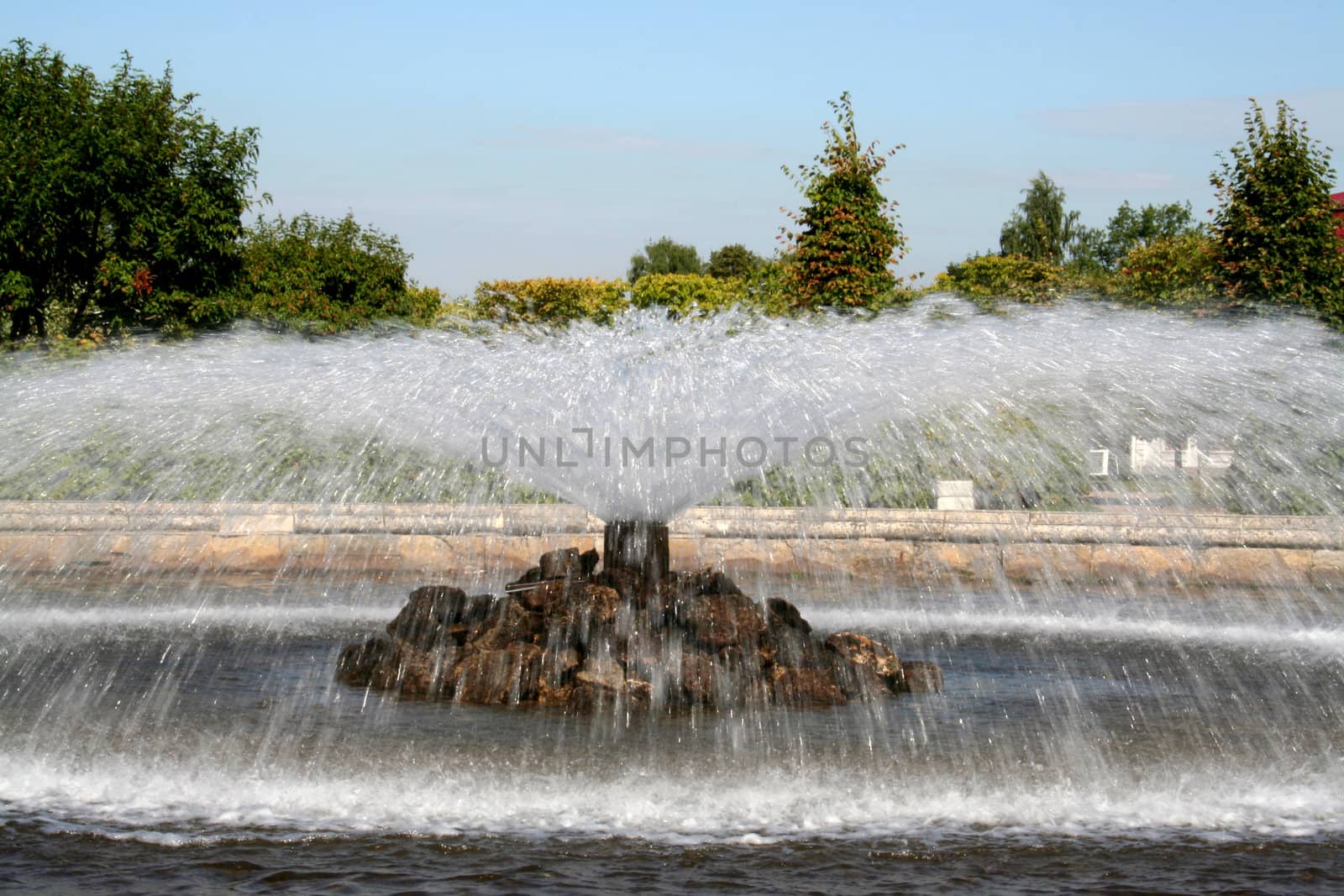 fountain in the garden, red roof and blue sky
