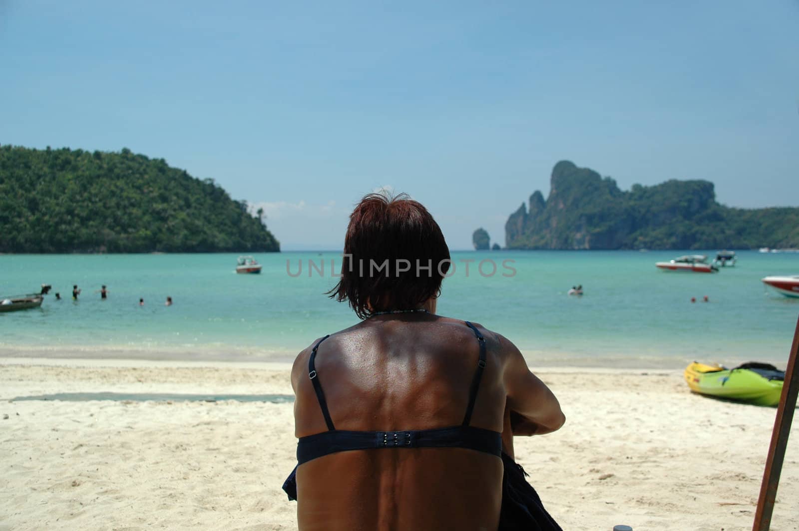 Woman sitting on a beach in Thailand enjoying the view