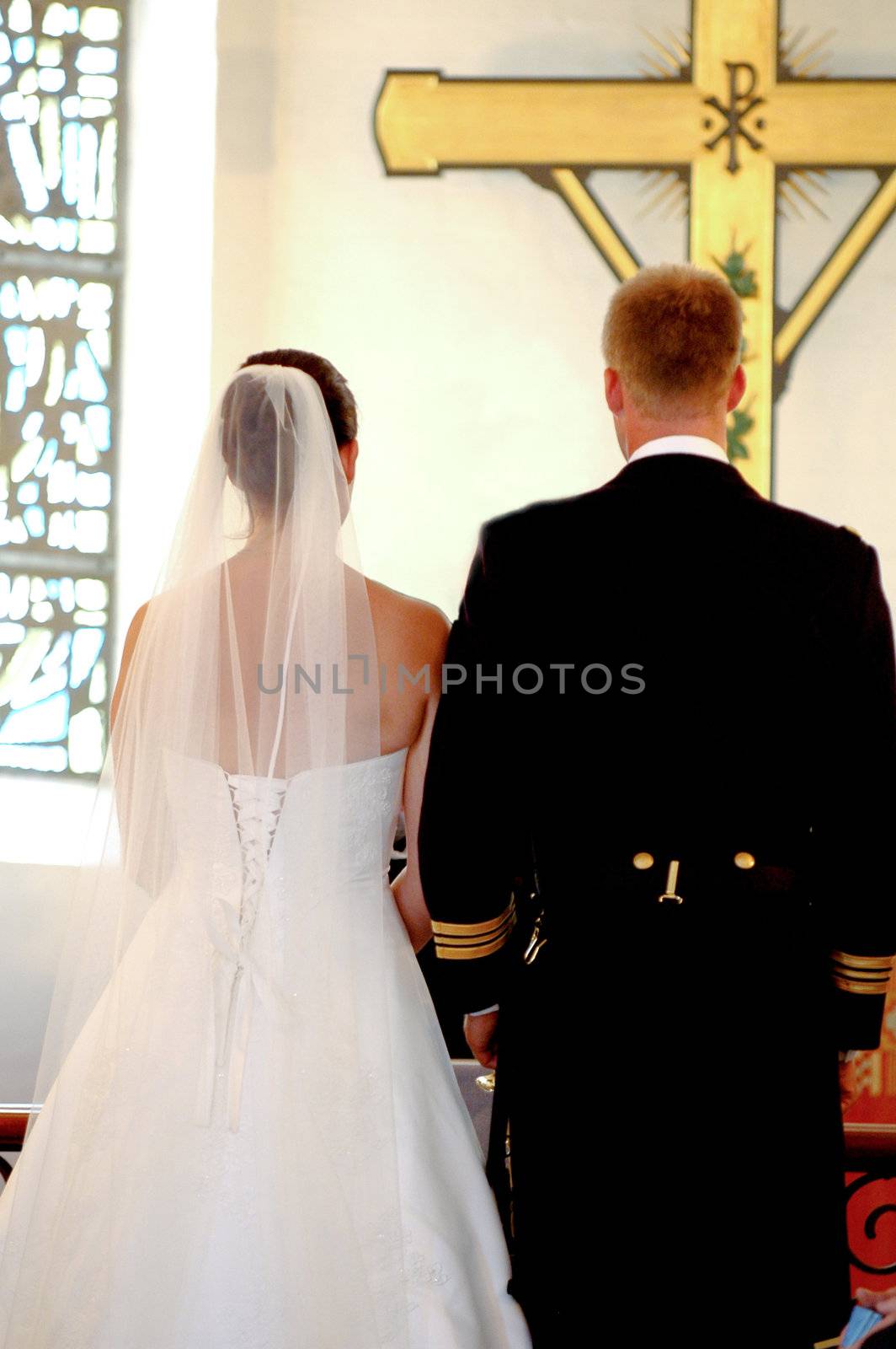 Wedding couple. The wedding couple is standing in front of a cross in church.