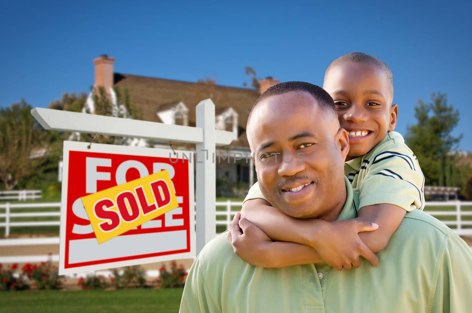 Father and Son In Front of Real Estate Sign and Home by Feverpitched