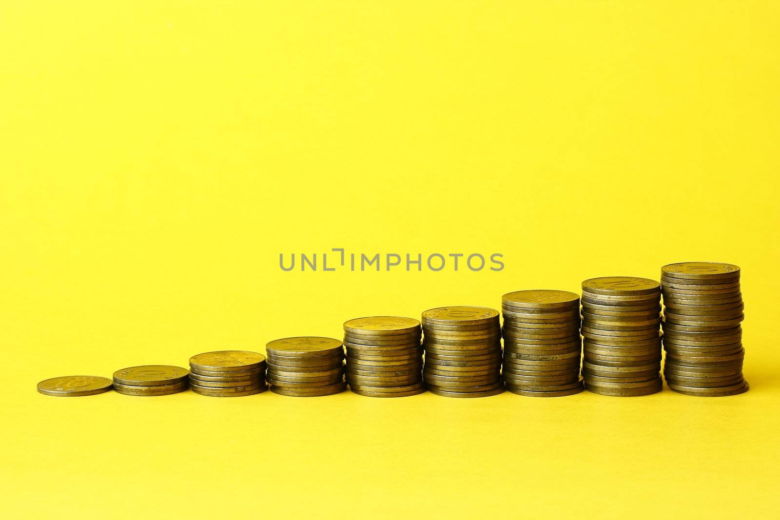 Coins Stack with yellow background close up
