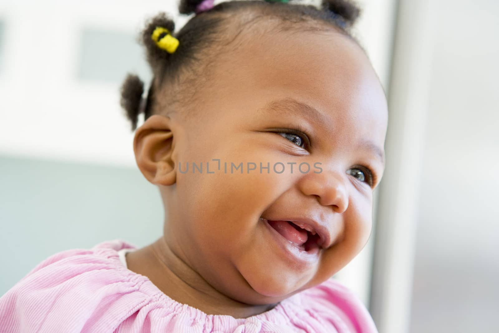 Baby indoors laughing by MonkeyBusiness