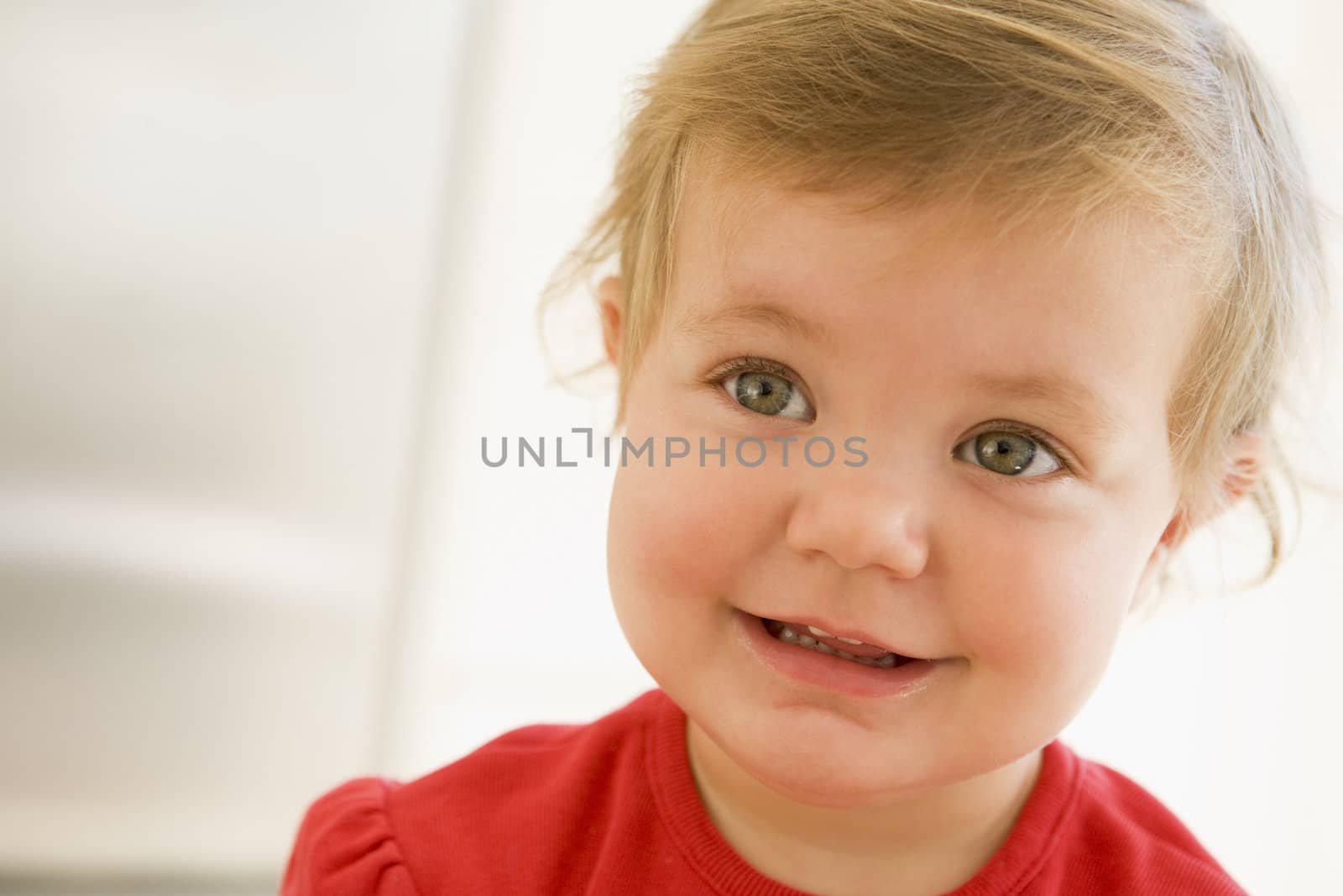 Baby indoors smiling by MonkeyBusiness