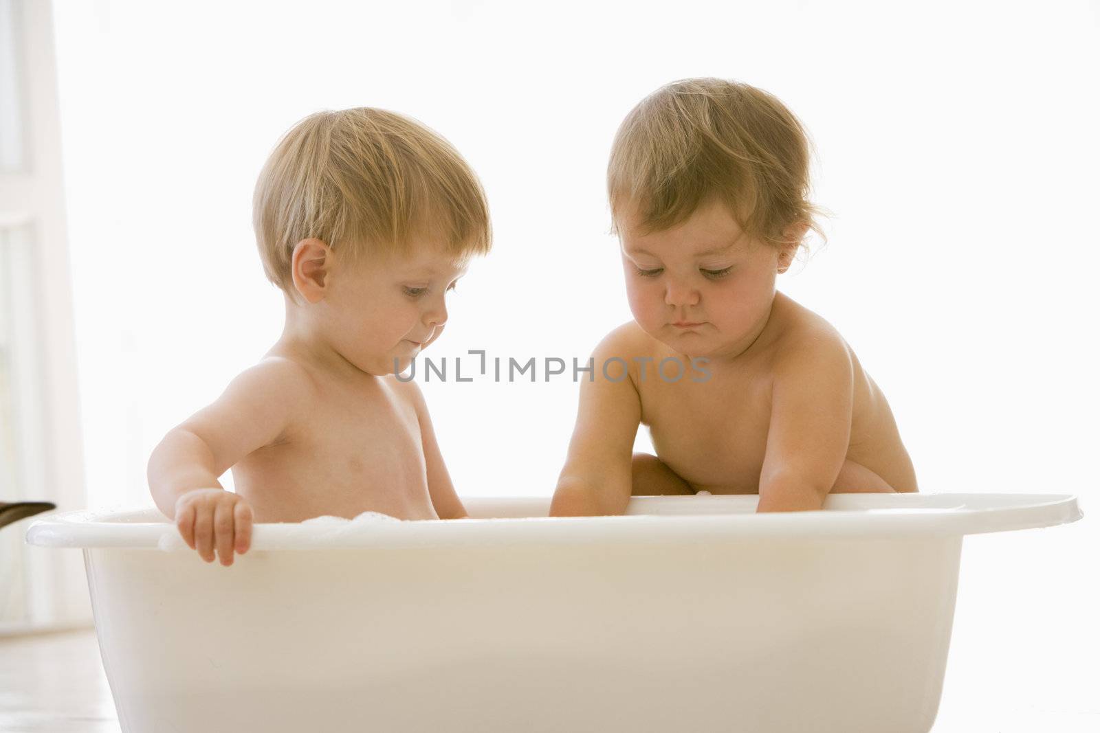 Two babies in bubble bath by MonkeyBusiness
