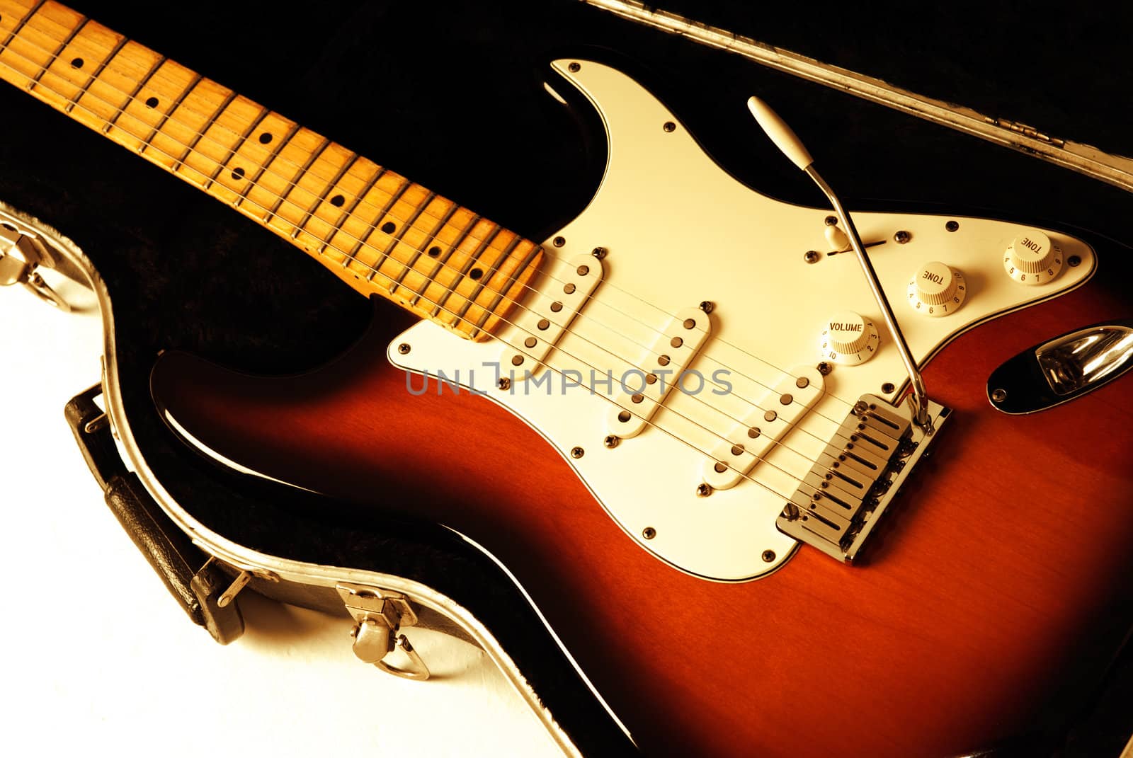 Electric guitar on case with orange lighting. 
