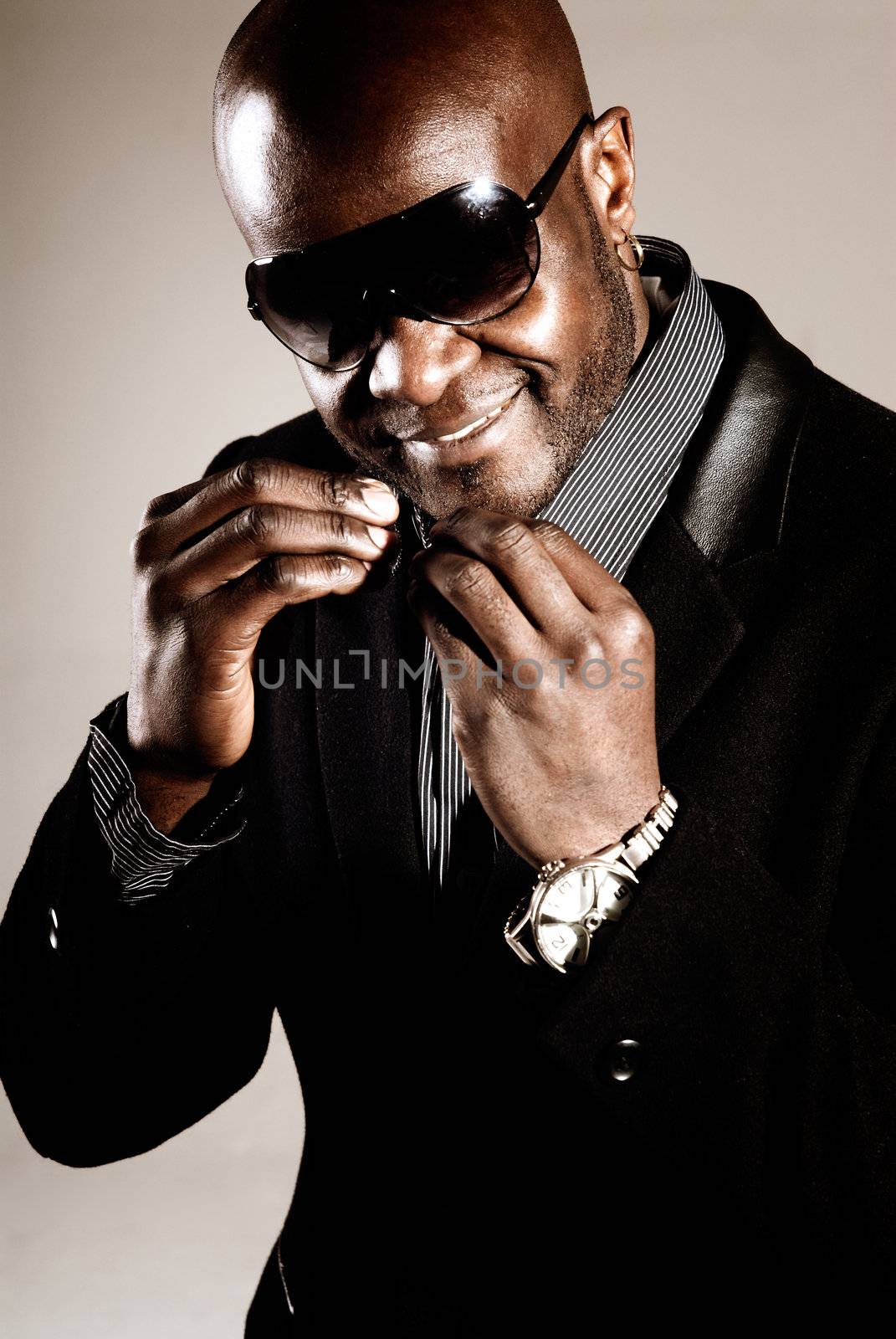 Black man posing with sunglasses and fashion style on low key "chocolate light". 