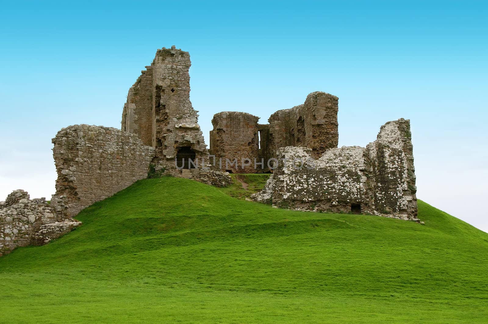 ancient ruins on a green hill covered with grass
