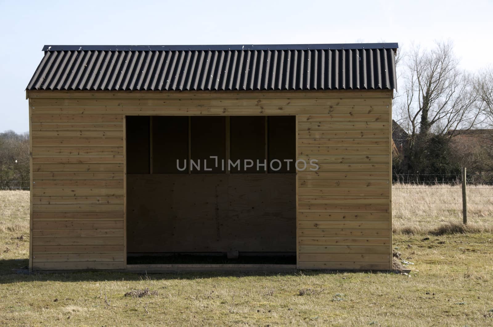 A wooden shed in field of grass