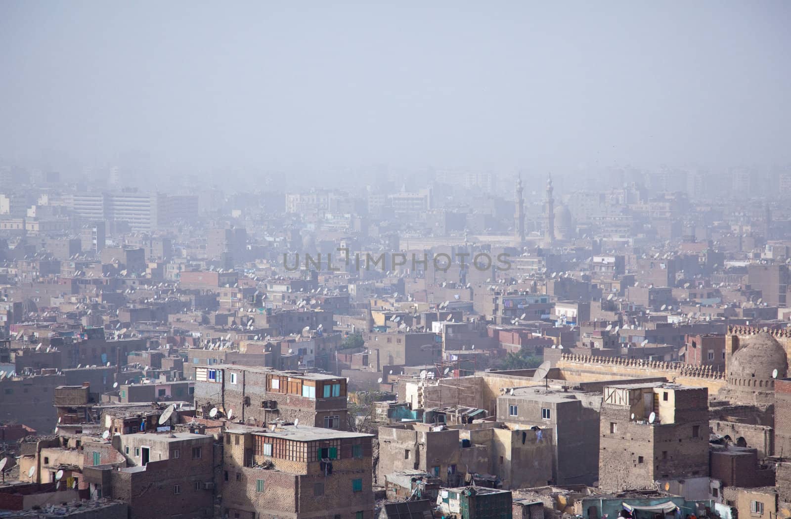 View into a misty city of Cairo in Egypt over roof top slums and mosques