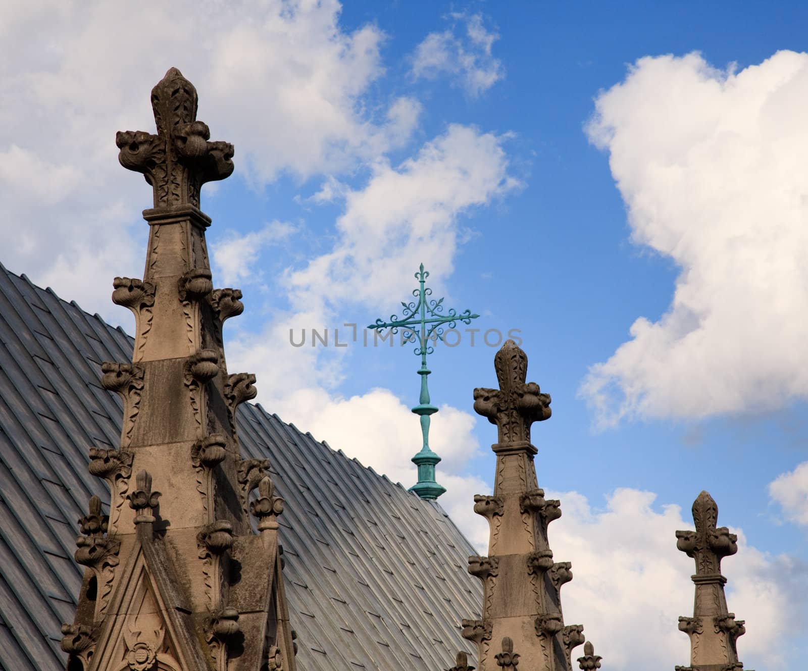 View over roof of cathedral towards wrought iron cross