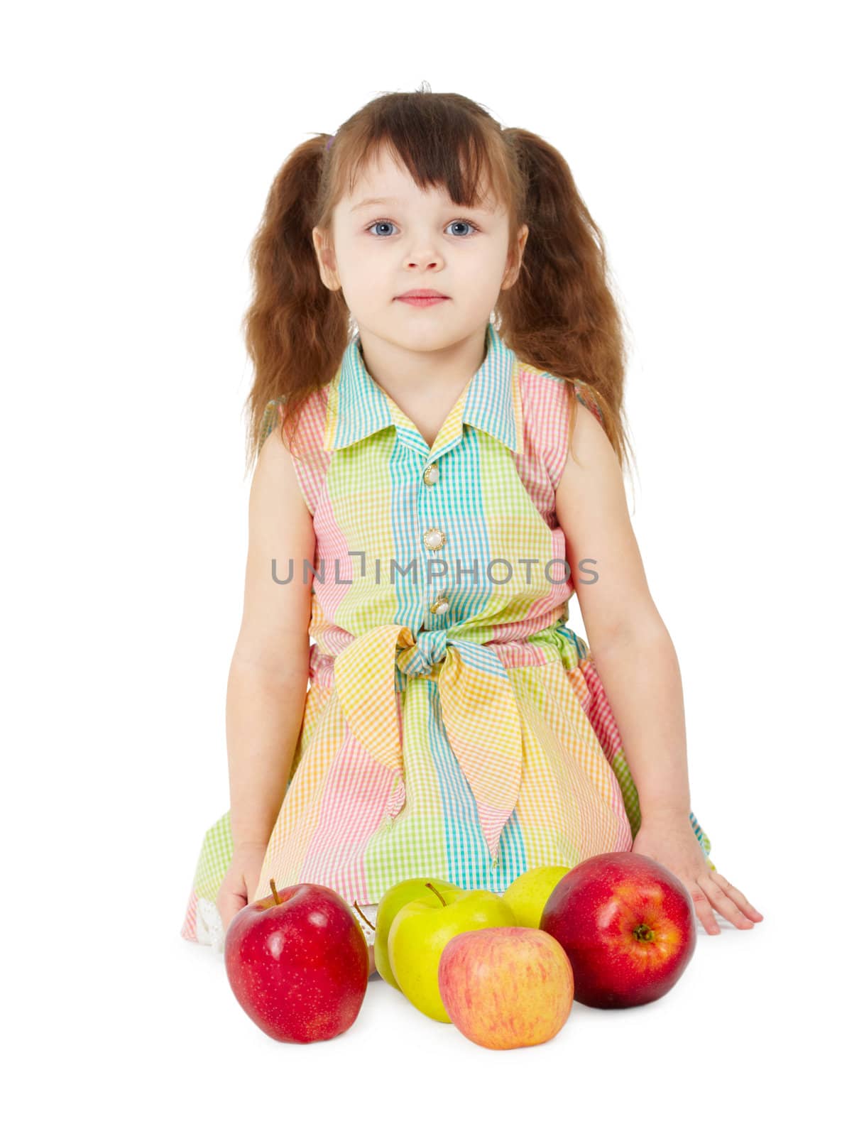 A little girl with the apples sits isolated on a white background
