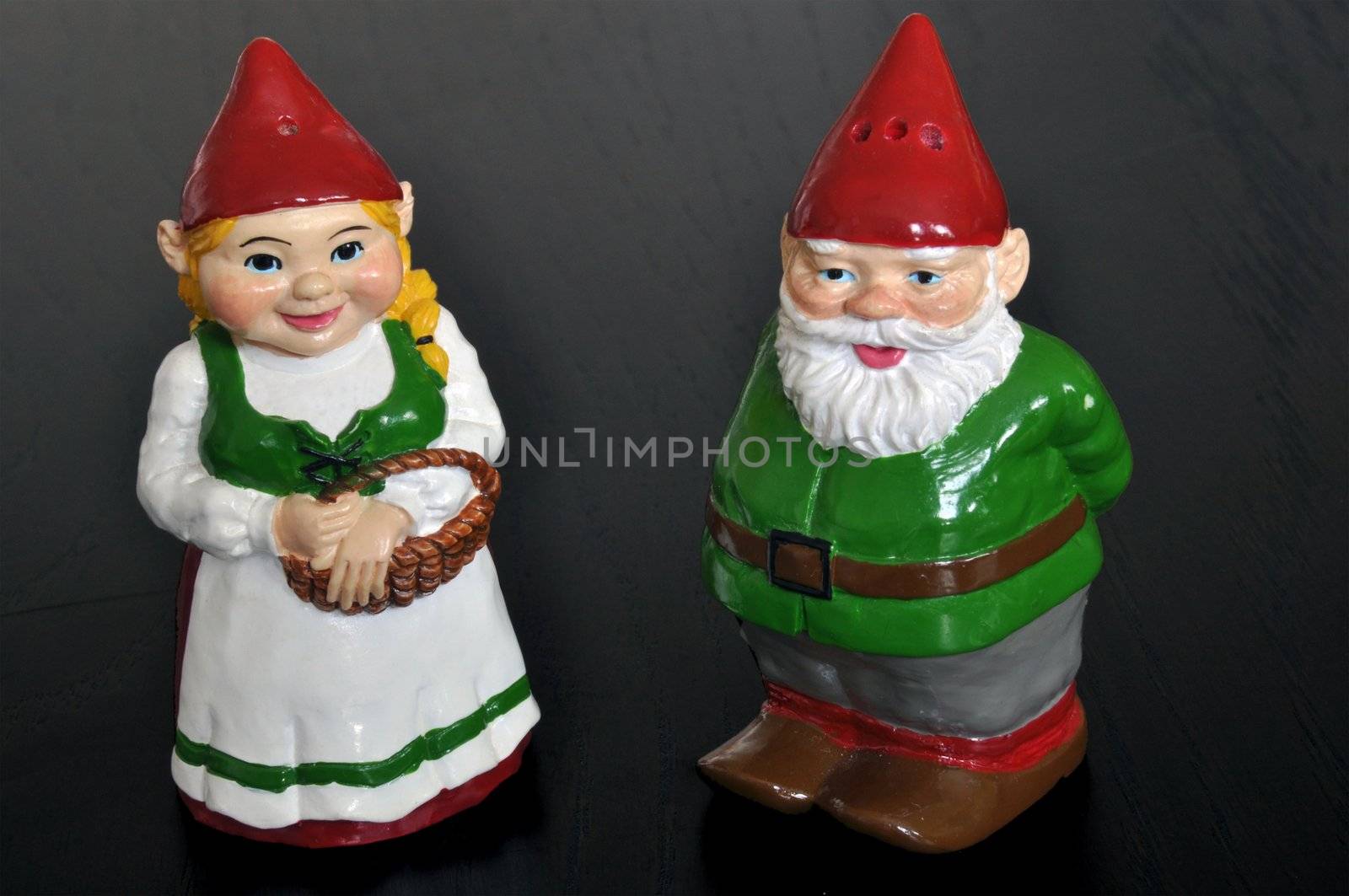Cute set of salt and pepper shakers designed as dwarfs on dark wooden table