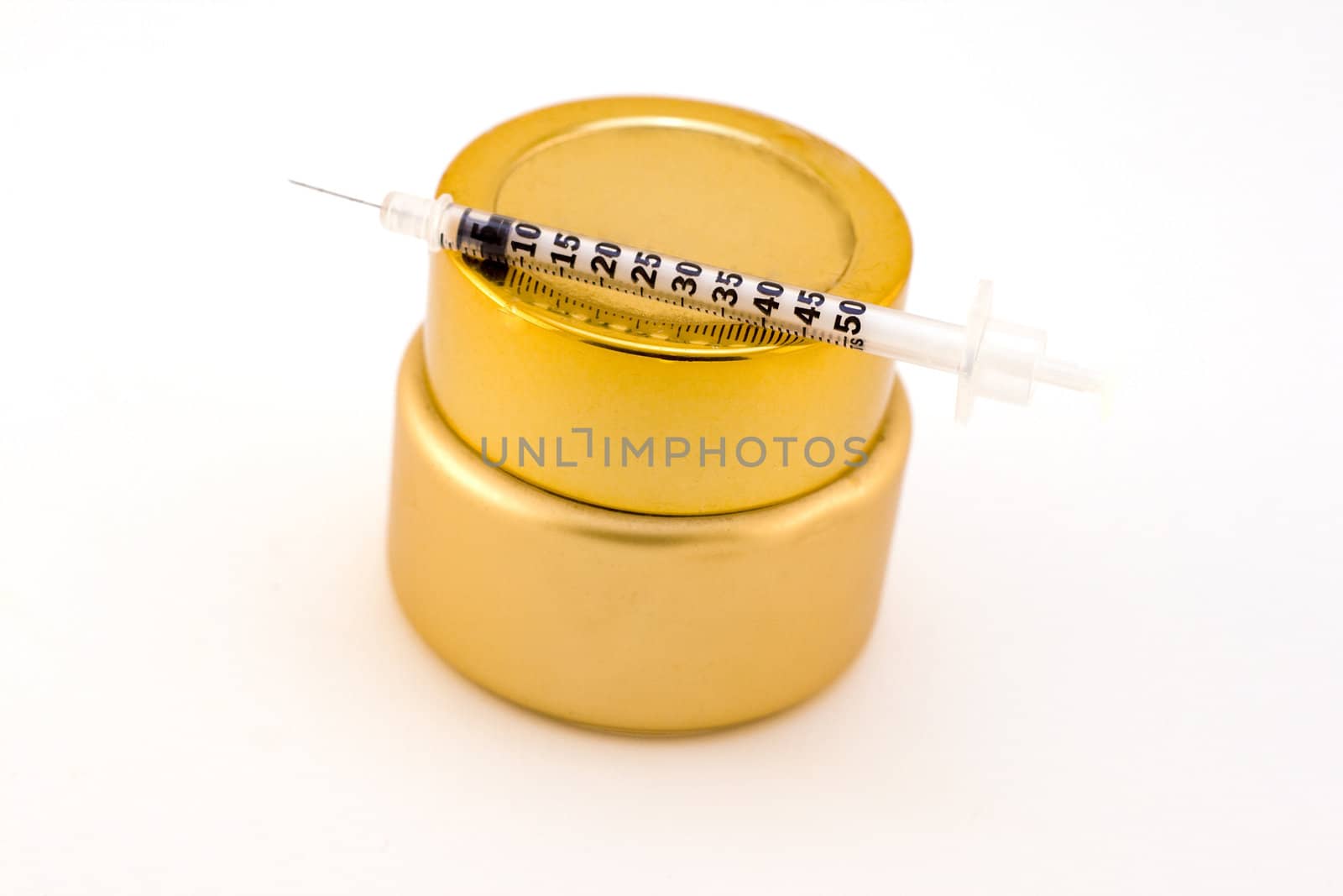 beauty product in gold jar with needle